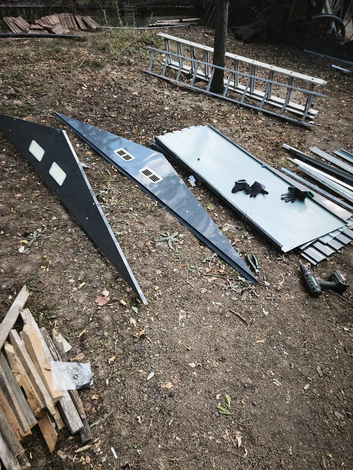 A kerti tároló elemei kirendezve a fűben, összeszerelés előtt