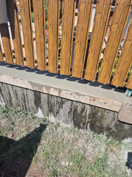 Az új léckerítés rögzítése a lábazaton.