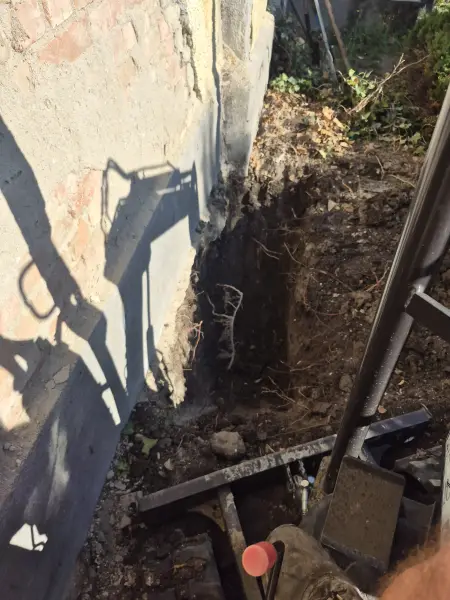 A minikotró a ház fala mellett, szűk sávban.