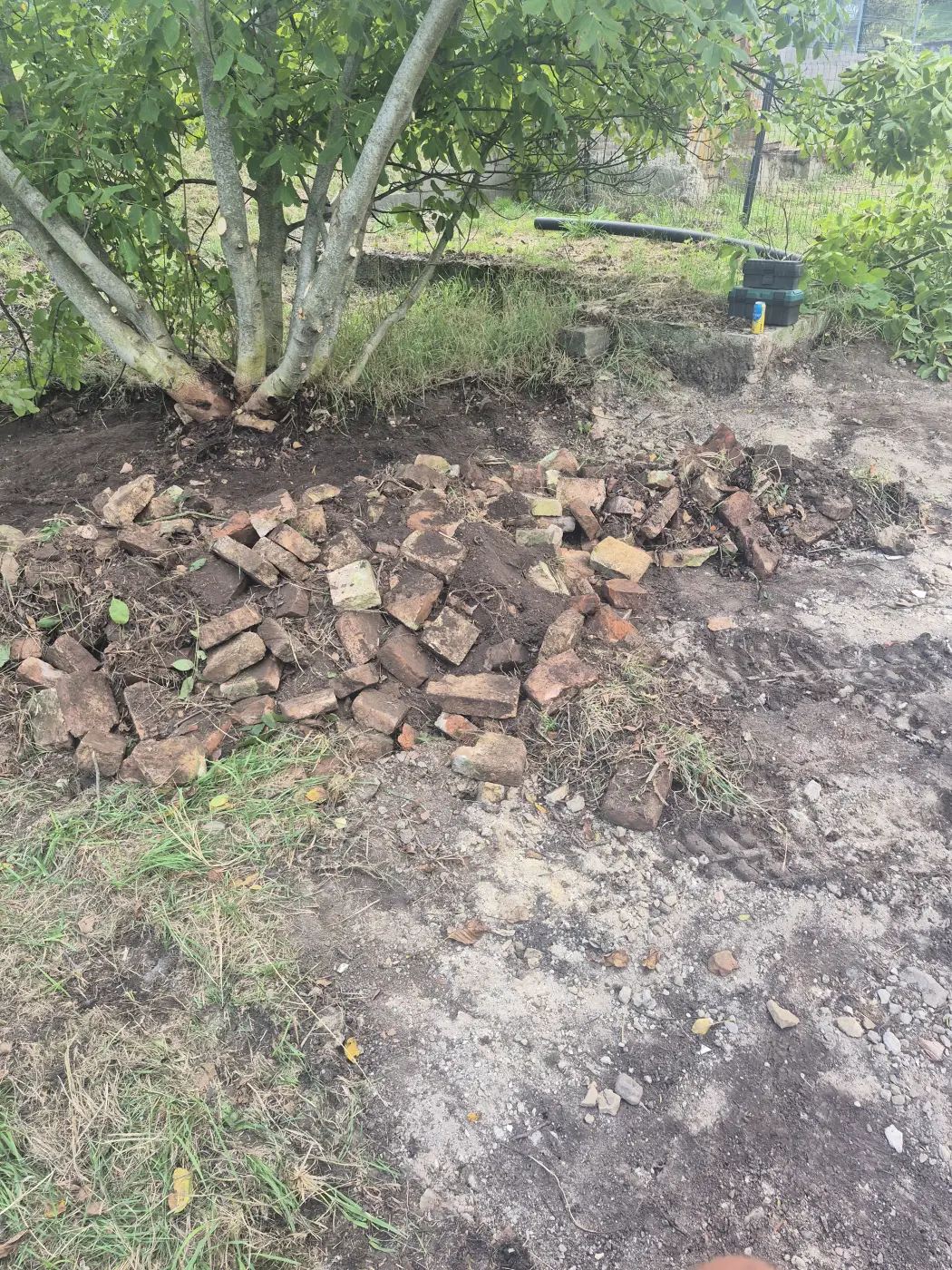 A megszüntetett kerti tó helye, a kibontott téglákkal.
