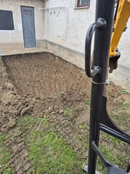 A kotró megkezdi a föld kiszedését.