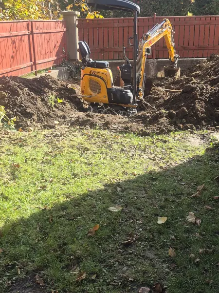 Gépi árokásás a füves udvaron, a nyomvonal mentén.