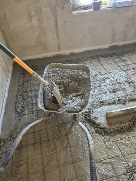 A beton bedolgozása a vasháló fölé.