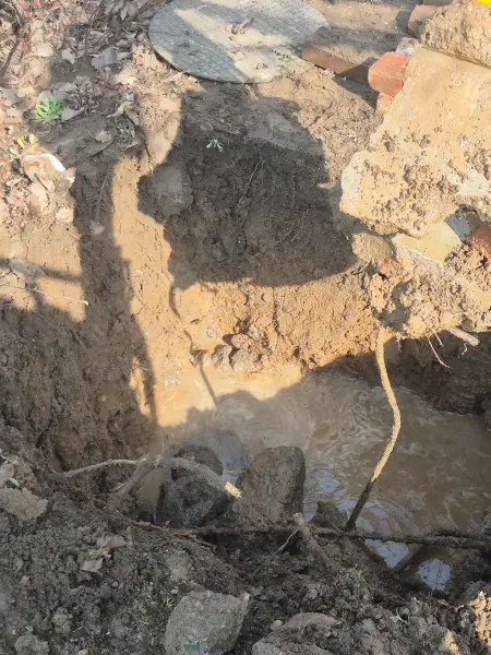 A régi vezeték feltárása a betontörmelék alatt.
