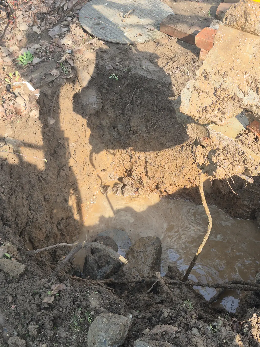 A régi vezeték feltárása a betontörmelék alatt.
