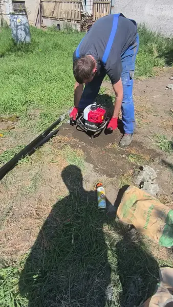Az oszlopgödrök fúrása motoros földfúróval.