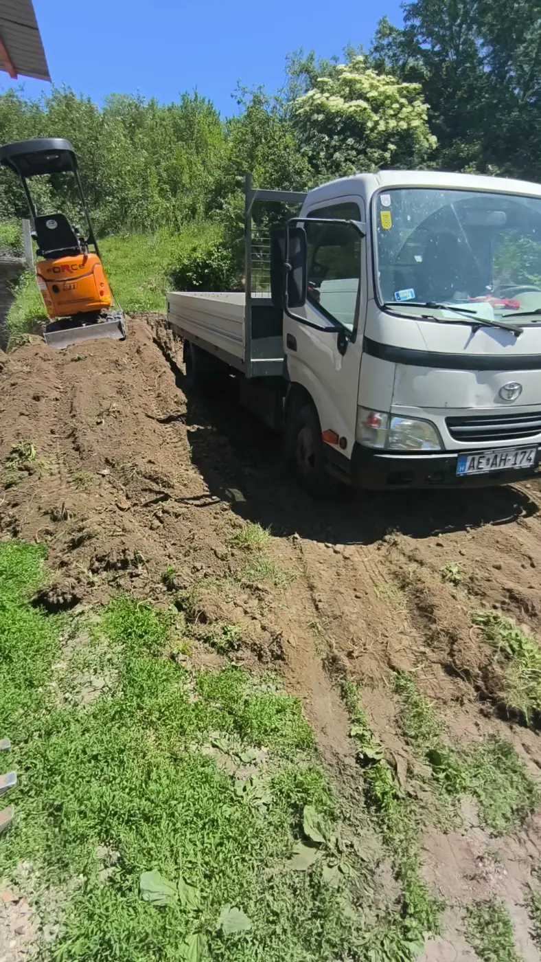 A minikotró a platóra rakodja a kitermelt földet.